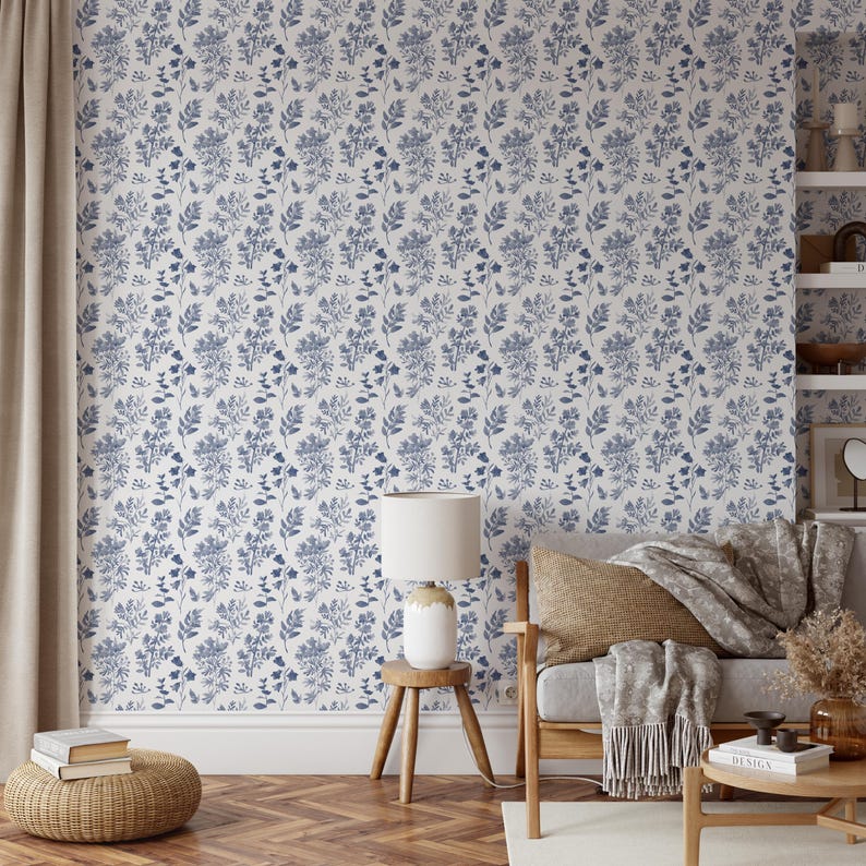 K&ouml;nnte beinhalten: Eine wei&szlig;e Tapete mit einem blauen Blumenmuster. Die Tapete befindet sich in einem Wohnzimmer mit einem Stuhl, einer Lampe und einem Beistelltisch.
