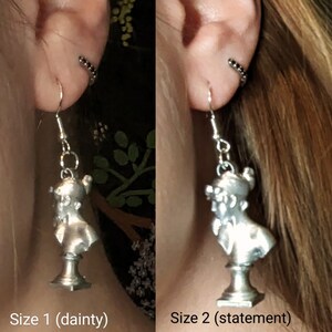 This photo shows a side-by-side of a blonde woman wearing a Sappho bust earring in the dainty size and the statement size.