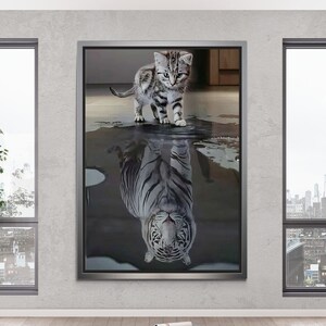 Könnte beinhalten: Ein gerahmter Druck eines schwarz-weißen Katers, der in eine Wasserpfütze schaut. Das Spiegelbild ist ein weißer Tiger.
