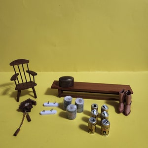 May include: A miniature wooden rocking chair, a small wooden bench, a cuckoo clock, two white shelves with hooks, a round wooden box, a stack of miniature cans, and a pair of brown boots on a yellow background.