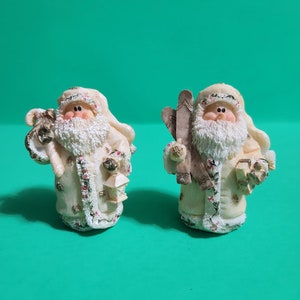 Set of 2 Cream Colored Santa Claus Figurines, One Carrying Skis and a Present and the Other a Candy Cane and Lantern  **Free Shipping**