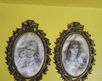 May include: Two oval framed pictures with ornate gold frames. Each picture features a black and white drawing of a woman holding a child.