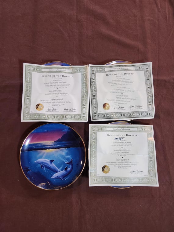 Various Dolphin Porcelain Plates Bordered in 24 Karat Gold From