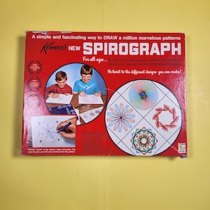 May include: Vintage Spirograph set in a red box. The box features illustrations of children using the Spirograph and examples of the patterns it creates. Text on the box reads "A simple and fascinating way to DRAW a million marvelous patterns."