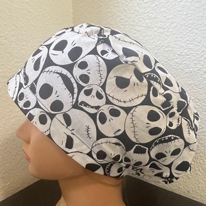 May include: Black and white scrub hat with a repeating pattern of Jack Skellington's face from The Nightmare Before Christmas.