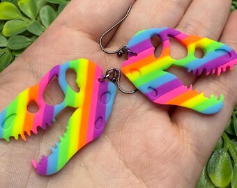 ¡Pendientes colgantes de esqueletos de dinosaurios raver! ¡Reaccionan a la luz negra y brillan con luz arcoíris! ¡Hechos a mano en Michigan!