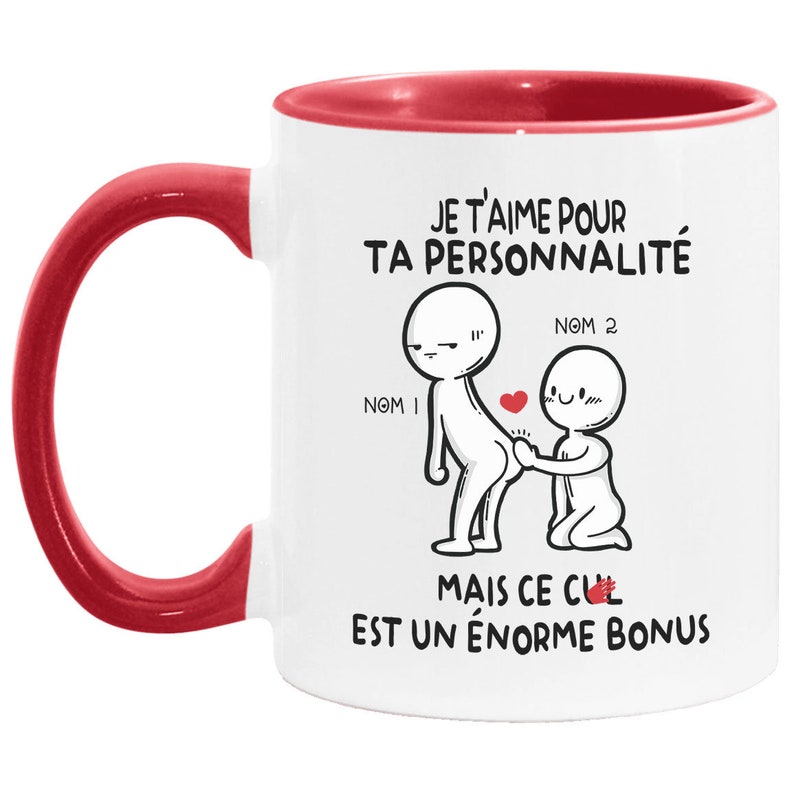 May include: White ceramic mug with a red rim and handle. The mug features a cartoon illustration of two stick figures with the text "JE T'AIME POUR TA PERSONNALIT&Eacute; MAIS CE CUL EST UN &Eacute;NORME BONUS".