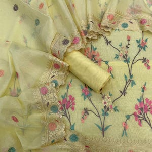 May include: A white ceramic mug with a black handle and the text "But First, Coffee" in a bold, black font. The mug is set against a blurred background, suggesting a cozy setting.