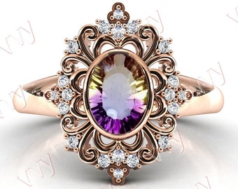 Puede incluir: Un anillo de oro rosa con una gran piedra preciosa ovalada engastada en un diseño de filigrana. La piedra preciosa es una amatista multicolor con tonos de púrpura, verde y amarillo. El anillo está adornado con piedras preciosas más pequeñas y transparentes.