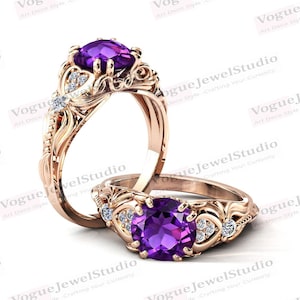 May include: Two gold rings with intricate designs. The rings feature a large, round, purple gemstone and smaller, clear gemstones. The rings are set against a white background.
