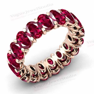 Könnte beinhalten: Ein Ewigkeitsring aus Roségold mit einer durchgehenden Reihe von ovalen Rubin-Edelsteinen.