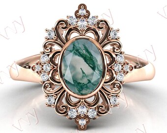 May include: A rose gold ring with a green agate oval gemstone surrounded by a delicate filigree design and small clear diamonds.