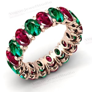 Può includere: Un anello di eternità in oro con pietre ovali rosse e verdi alternate. L'anello è incastonato con una fila continua di pietre preziose.