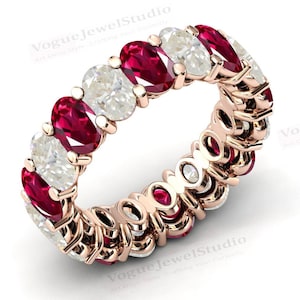May include: A rose gold eternity band featuring alternating oval-shaped rubies and diamonds. The ring is set with a continuous row of gemstones.