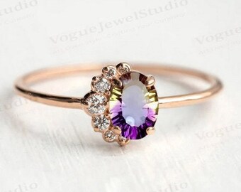 Puede incluir: Un anillo de oro rosa con una piedra ovalada de color púrpura y verde rodeada por un halo de pequeños diamantes.