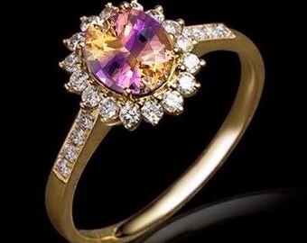 Puede incluir: Un anillo de oro con una gran piedra preciosa ovalada engastada en un halo de diamantes más pequeños. La piedra preciosa es una mezcla de morado, rosa y amarillo.