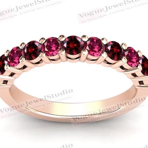 May include: A rose gold band ring with a row of pink gemstones. The ring is set with a total of 10 stones.