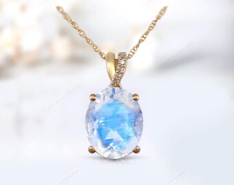 Può includere: Una collana con catena d'oro con un ciondolo che presenta una grande pietra di luna ovale con un effetto arcobaleno e diamanti più piccoli incastonati nell'oro.