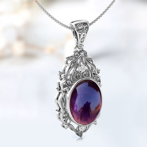 May include: A silver pendant necklace with an ornate design featuring a large oval-shaped purple gemstone surrounded by smaller clear gemstones.