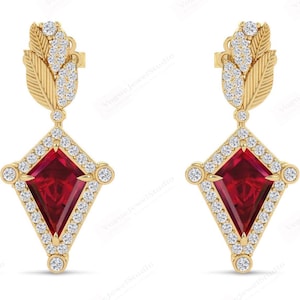 Op de afbeelding: Een paar gouden oorbellen met een rode edelsteen en diamant accenten. De oorbellen hebben een bladontwerp en een geometrische vorm.