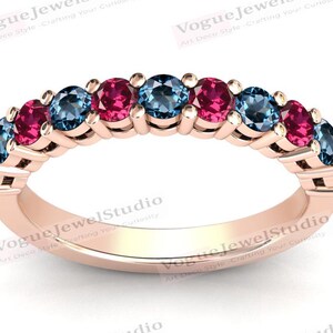 May include: A rose gold band ring with alternating blue and pink gemstones. The ring is set with round stones.