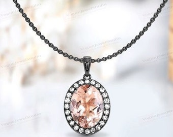 May include: A black chain necklace with a pendant featuring a large oval-shaped pink gemstone surrounded by a halo of smaller clear gemstones.