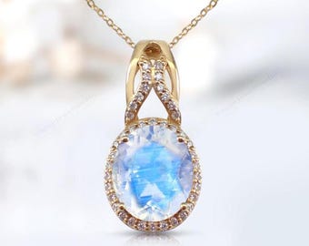 May include: A gold necklace with a pendant featuring a large oval moonstone surrounded by a halo of smaller diamonds. The pendant is attached to a delicate gold chain.