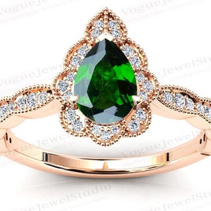 May include: A pear-shaped green gemstone ring set in rose gold with a delicate floral halo and a band of small diamonds.