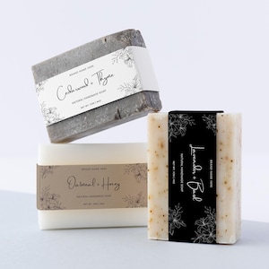 May include: Three bars of natural handmade soap with different scents: Cedarwood & Thyme, Oatmeal & Honey, and Lavender & Basil. Each bar has a label with a floral design and the scent name.