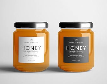 Könnte beinhalten: Zwei Honiggläser mit schwarzen Etiketten. Die Etiketten haben weißen Text, der "BRAND NAME HERE HONEY Wildflower Honey 100% Pure Organic Honey No Preservatives - Raw & Unfiltered 230 ML / 8.3 OZ" lautet.