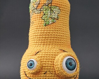 Unusual yellow crochet pumpkin with asymmetrical eyes and leaf embroidery. Halloween table decor, fall gift for friend