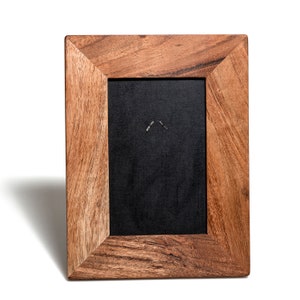 Puede incluir: Un marco de fotos de madera con un acabado marr&oacute;n oscuro. El marco tiene un dise&ntilde;o sencillo con una abertura rectangular para una foto o una obra de arte.