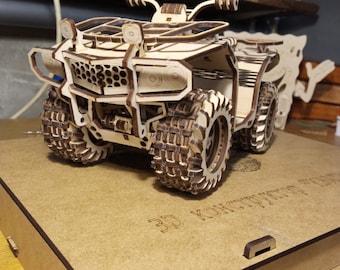 May include: A wooden model of an ATV, or all-terrain vehicle, with a detailed design. The model is assembled and ready to be displayed. The model is sitting on a wooden base with the text "3D Конструктор" printed on it.