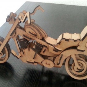 May include: A wooden model of a motorcycle with a brown finish. The motorcycle has a detailed design with a seat, handlebars, and wheels.