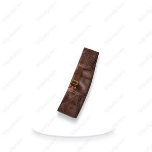 May include: A brown velvet wig grip with adjustable straps and a red buckle. The grip is designed to help secure a wig in place.
