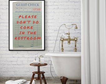 May include: A white bathroom with a white brick wall, a white bathtub with gold fixtures, and a framed print that reads "GUEST CHECK 107369 PLEASE DON'T DO COKE IN THE RESTROOM".