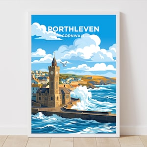 May include: A framed art print featuring a coastal scene of Porthleven, Cornwall. The artwork depicts a clock tower, buildings, and crashing waves under a blue sky with clouds. The text "Porthleven Cornwall" is at the top.