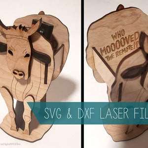 May include: A wooden cow-shaped remote control holder with the text "WHO MOOOOVED THE REMOTE!?" engraved on the back. The holder is made of light brown wood and has a black base.