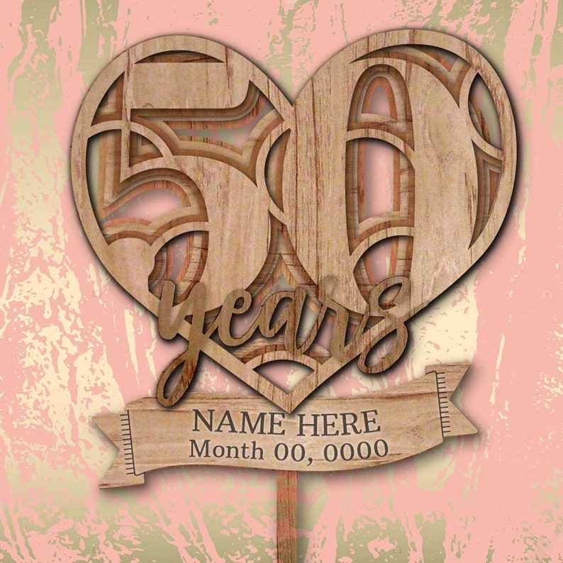 Pu&ograve; includere: Topper per torta di legno a forma di cuore con il numero 50 all'interno del cuore e la parola "anni" sotto. Uno striscione in basso dice "NAME HERE Month 00, 0000".
