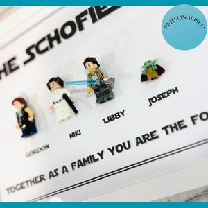 May include: A personalized family print featuring Lego Star Wars figures. The names Gordon, Niki, Libby, and Joseph are printed below the figures. The text "TOGETHER AS A FAMILY YOU ARE THE FOR" is also visible.