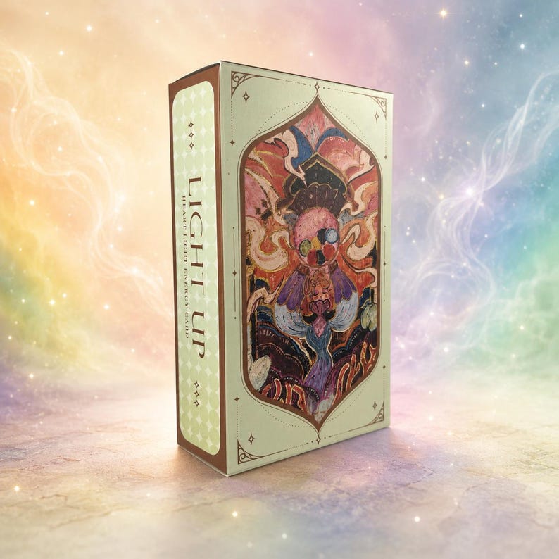 May include: A rectangular box with the words "LIGHT UP HEART LIGHT ENERGY CARD" printed on the side. The box features an ornate, colorful illustration of a figure with a detailed design. The box has a light green background with a brown border.