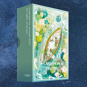 May include: A green box with the text "Cardamom Dreams" on the front. The box features an illustration of a boat with a person in it, surrounded by water lilies and other aquatic plants. The text "Copyright by Jovenly 2024" and "All rights reserved" are printed on the side of the box.