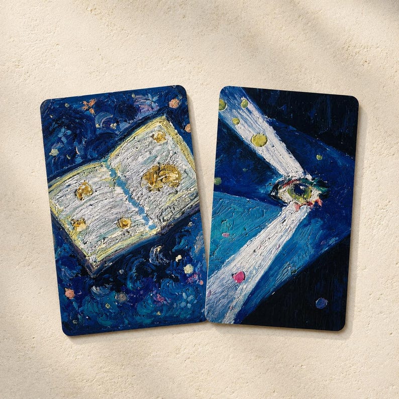 May include: Two rectangular art prints with rounded corners. One depicts an open book with gold accents against a dark blue background. The other shows an eye with light beams, also on a dark blue background.