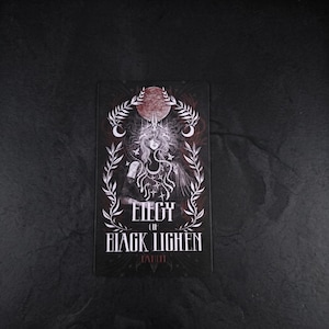 Op de afbeelding: Een rechthoekige kaart met een donkere illustratie van een figuur met lang haar, een kroon en sterachtige patronen. De tekst luidt ELEGY OF BLACK LIGHEN TAHITI. Het ontwerp is omlijst door witte bladeren en een rode maan op een zwarte achtergrond.