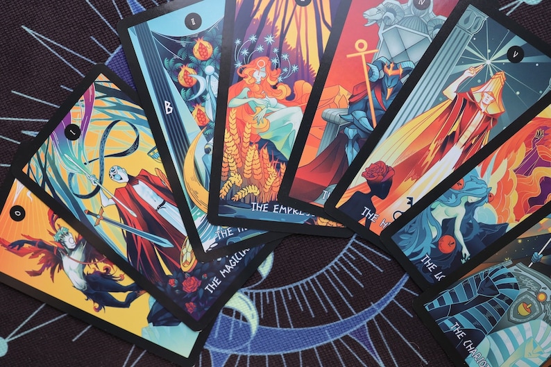 K&ouml;nnte beinhalten: Eine Tarotkarten-Auslage mit bunten Illustrationen und schwarzen R&auml;ndern. Die Karten beinhalten Der Magier, Die Kaiserin, Der Wagen, Die Hohepriesterin, Der Stern und Der Turm.