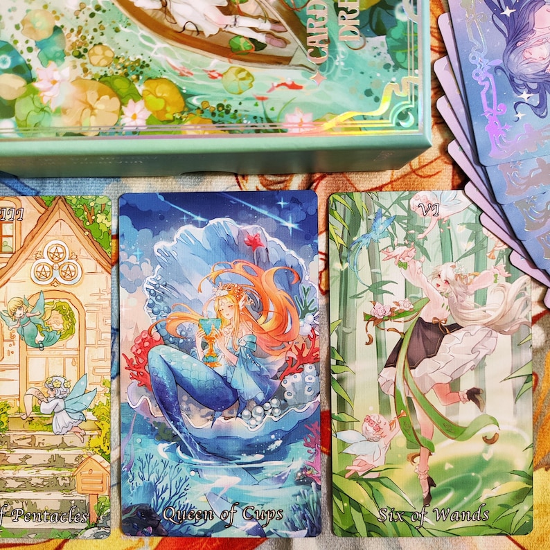 May include: Three tarot cards with illustrations of fairies. The card on the left is the Ten of Pentacles, the middle card is the Queen of Cups, and the card on the right is the Six of Wands.