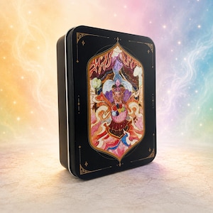 May include: A black rectangular tin with a colorful illustration of a figure with a crown and a multi-colored sphere. The illustration is framed by a gold border and set against a gradient background.