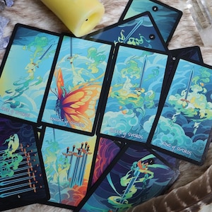 K&ouml;nnte beinhalten: Ein Satz Tarotkarten mit einem Schmetterlingsdesign in Blau-, Gr&uuml;n- und Gelbt&ouml;nen. Die Karten sind mit den Schwertkarten beschriftet, darunter der Ritter der Schwerter, die K&ouml;nigin der Schwerter und der K&ouml;nig der Schwerter.