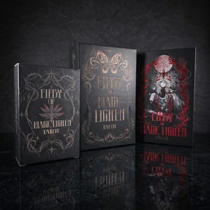 May include: Three black rectangular tarot card boxes titled Elegy of Black Lighen. The boxes feature intricate gold and red foil illustrations of butterflies, thorny vines, and a central figure with a crown under a large moon, all on a dark background.