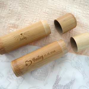 May include: Two bamboo tubes with engraved names and dates. The tube on the left says "Lucky" and the tube on the right says "Bailey 11.18.2024".